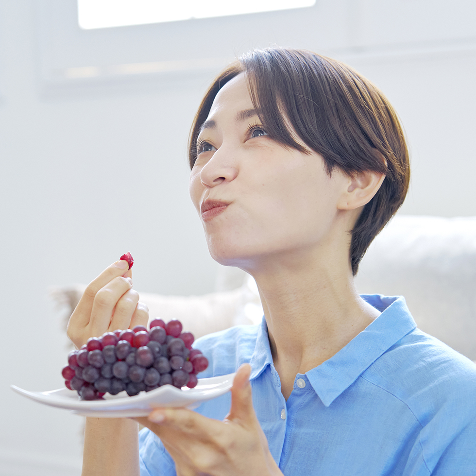 ぶどうを食べる女性