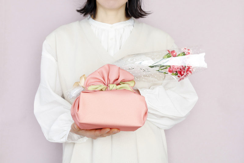 お花とプレゼントを持つ女性