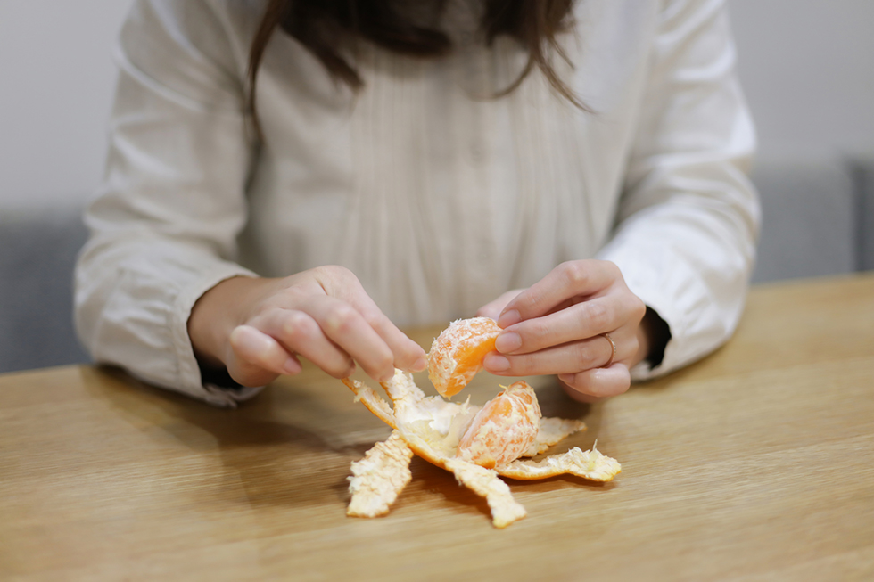 みかんをむく女性